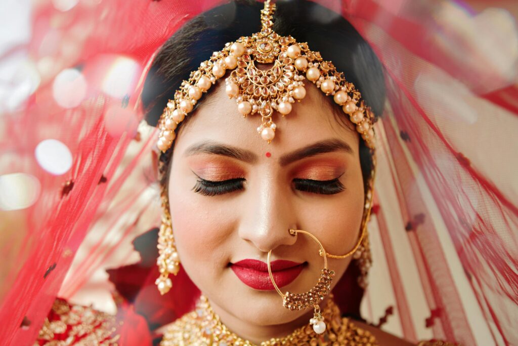 Close-up of a stunning Indian bride wearing traditional jewelry and makeup.